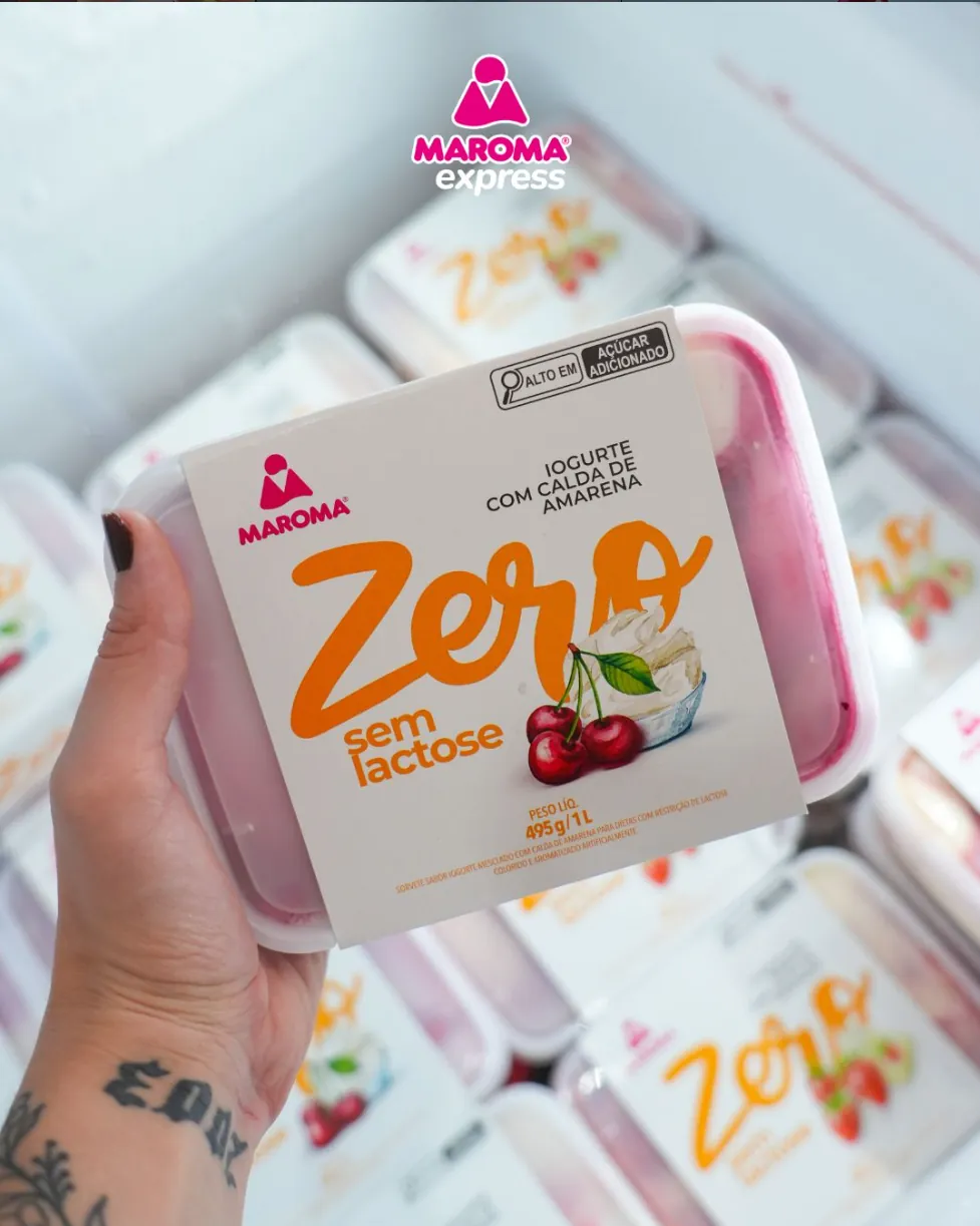 Pote Maroma Zero sem lactose sabor iogurte com calda de amarena segurado em frente ao freezer